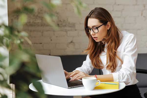 young businesswoman looking confused at her laptop